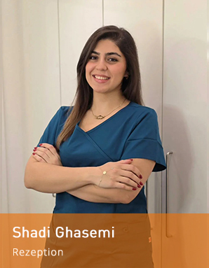 Freundliche Mitarbeiterin an der Rezeption und in der Assistenz, lächelnd mit verschränkten Armen